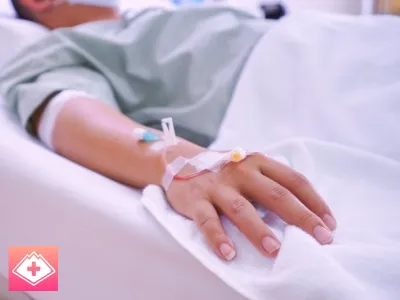 У мужчины в руке капельница Мужчина лежит под капельницей